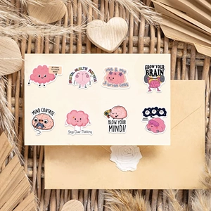 Detail of cartoon brain mental health stickers with pink motifs on a beige card layout