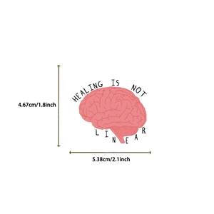 Detail of pink brain sticker with Healing Is Not Linear quote for guitar and laptop