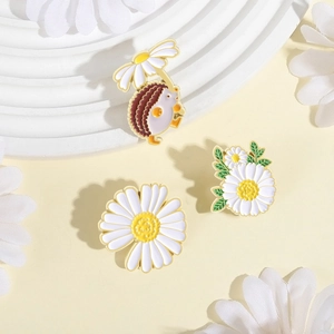 Three-piece daisy enamel pin set featuring a cute hedgehog, flower clusters, and a large blossom