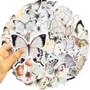 Hand met een kleurrijke waterdichte vlindersticker voor doe-het-zelf decoratie en koffers