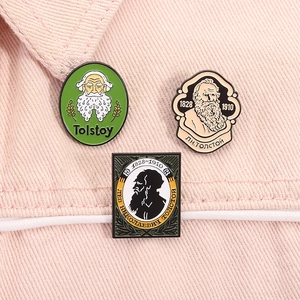 Detail of three Leo Tolstoy enamel pins featuring literary portraits on fabric background
