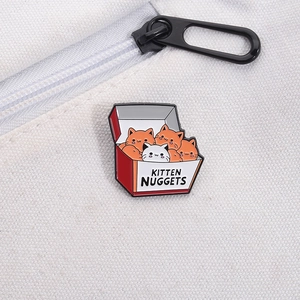 Dettaglio della spilla smaltata Kitten Nuggets su una borsa in tela con cerniera