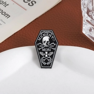 Detail of gothic coffin enamel pin with Memento Mori text and skeleton on vintage background