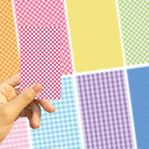 Detail of pink checkered DIY phone case decorative sticker held in hand for sizing