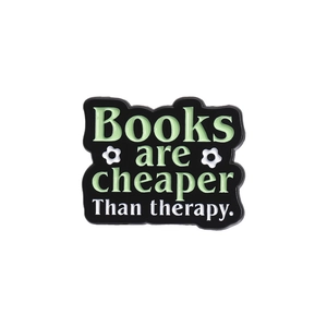 Detail of enamel pin with Books are cheaper Than therapy text and floral accents