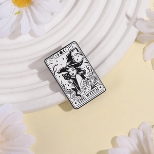 Enamel tarot card pin featuring black cat and The Witch design on a white pedestal
