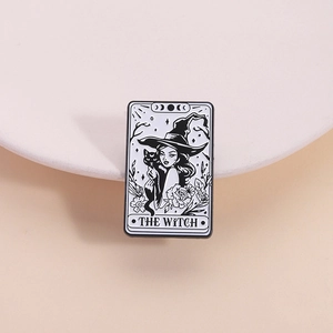 Tarot-style enamel brooch featuring a witch and black cat in black and white design