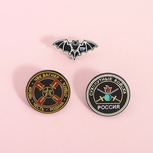 Three Russian military enamel pins featuring bat and Wagner group emblem on pink background