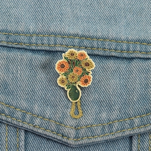 Broche en émail tournesol artistique inspirée de Van Gogh sur une veste en denim bleu