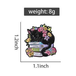Detail showing cartoon black cat sleeping on books enamel pin with 1.2x1.1 inch dimensions