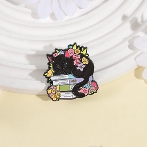 Cartoon black cat sleeping on stack of books enamel pin with colorful flowers