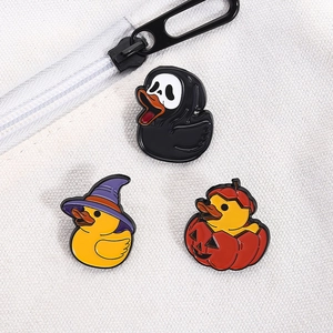 Detail of Halloween enamel pins with duck ghost and pumpkin motifs on white canvas bag