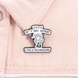 Detailaufnahme der lustigen Frosch-Emaille-Anstecknadel auf einer rosa Jeansjacke