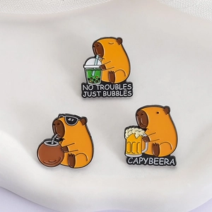 Three cute capybara enamel pins with boba tea and beer designs on a white background