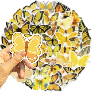 Detailopname van gele vlinderstickers met een hand om de grootte aan te geven