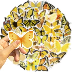 Detail van hand die een gele vlindersticker vasthoudt met waterdichte decoratieve decals