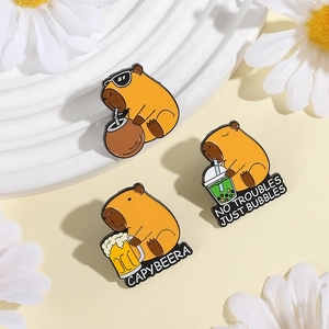 Detailed close-up of cute enamel capybara pins with beer and bubble tea themes