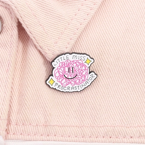 Detail of pink Little Miss Procrastinator enamel pin pinned on pink denim jacket