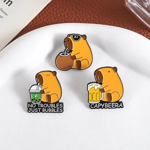 Three cute capybara enamel pins set with fun slogans on white ceramic plate
