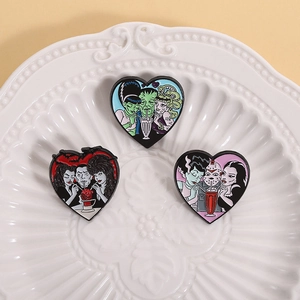 Tres pines de esmalte con forma de corazón y personajes monstruos en bandeja
