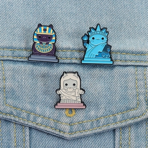 Set of three creative cat enamel pins featuring world landmarks on denim jacket