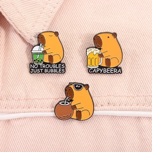 Detailed view of three cartoon Capybara enamel pins on pink denim jacket clothing