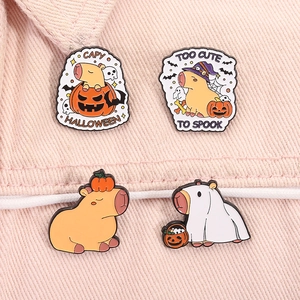 Close-up of four Halloween capybara enamel pins on pink denim with pumpkins and ghosts