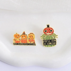 Set di spille smaltate di Halloween con spaventapasseri zucca e testo su sfondo bianco