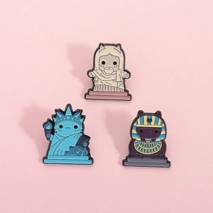 Three creative cat enamel pins shaped as Statue of Liberty, Pharaoh, and classical bust