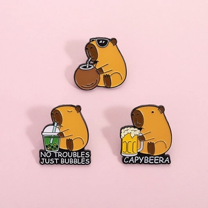 Three cute Capybara enamel pins featuring funny drinking poses on a pink background