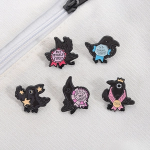 Detailed view of 5 unique raven enamel pins with motivational quotes on canvas