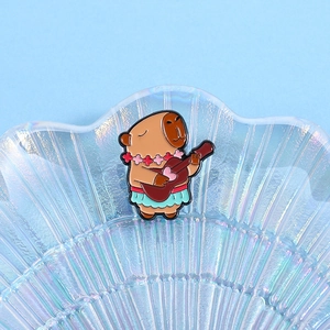 Close-up of Capybara enamel pin with hula skirt and ukulele on iridescent tray