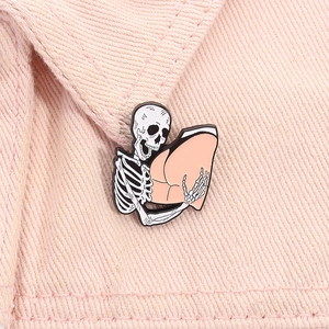 Skeleton hands holding buttocks enamel pin on pink denim jacket collar accessory