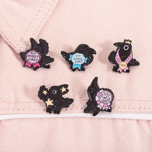 Detail view of five crow enamel pins with motivational quotes on pink denim background