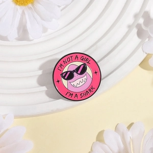 Détail du pin's requin rose en émail avec l'inscription I'M NOT A GIRL I'M A SHARK