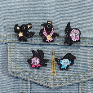 Set of 5 black raven enamel pins with motivational quotes on denim jacket pocket