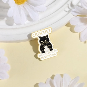 Cute black cat enamel pin knitting white yarn with humorous quote on yellow background