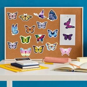 Close-up van levendige vlinderstickers met witte randen op een creatief kurkbord