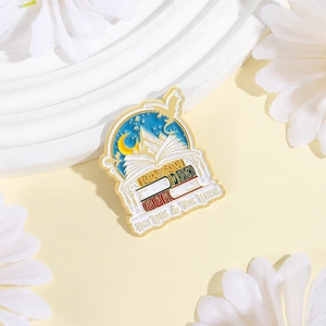 Macro detail of enamel pin featuring books and dragons with High Lords & Wing Leaders text