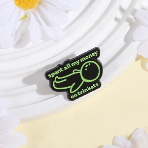 Pin de esmalte negro y verde neón con frase divertida sobre gastar dinero en joyas