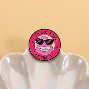 Badge rond en émail rose avec requin et slogan dans un coquillage blanc élégant