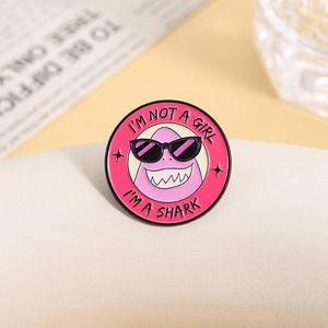 Pin's en émail avec requin rose et slogan I'M NOT A GIRL I'M A SHARK sur badge rond