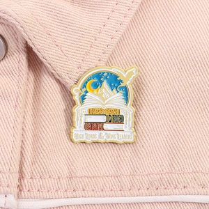 Detail of the fantasy book enamel pin with High Lords and Wing Leaders text on pink denim