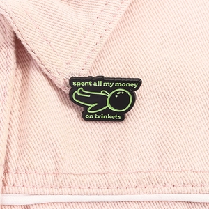 Detalle de broche esmaltado con frase creativa sobre tela denim rosa
