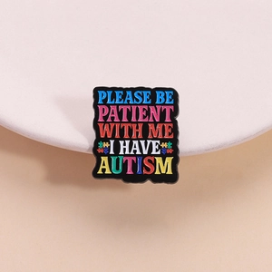 Broche en émail pour l'autisme avec texte descriptif et motif de puzzle multicolore