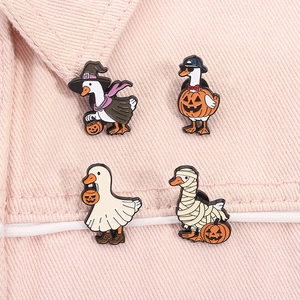 Close-up of four Halloween enamel pins with funny duck ghosts and pumpkin designs
