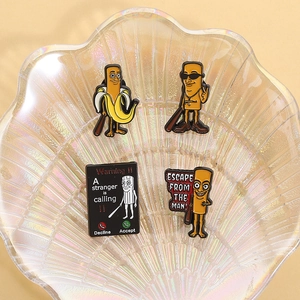 Macro detail of four artistic enamel pins on a shell tray featuring internet meme designs