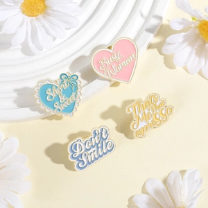 Pastel heart and slogan enamel pins on white steps with daisies, macaron style accessories