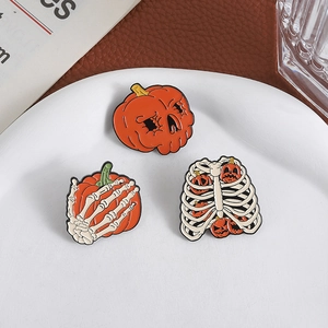 Set di spille smaltate di Halloween con teschi di zucca e mani di scheletro su piatto