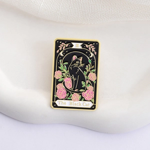Tarot card style black cat enamel brooch with pink roses on a white display plate